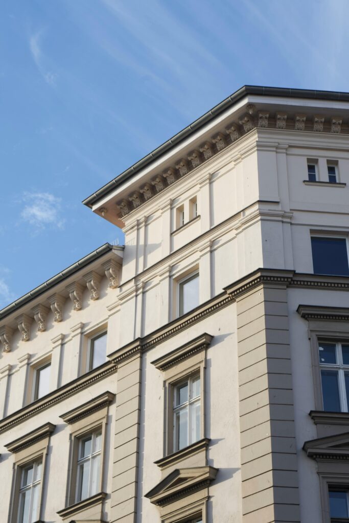 Real Estate Transactions & Litigation A detailed view of a classic urban building facade, showcasing architectural elegance under a bright blue sky.